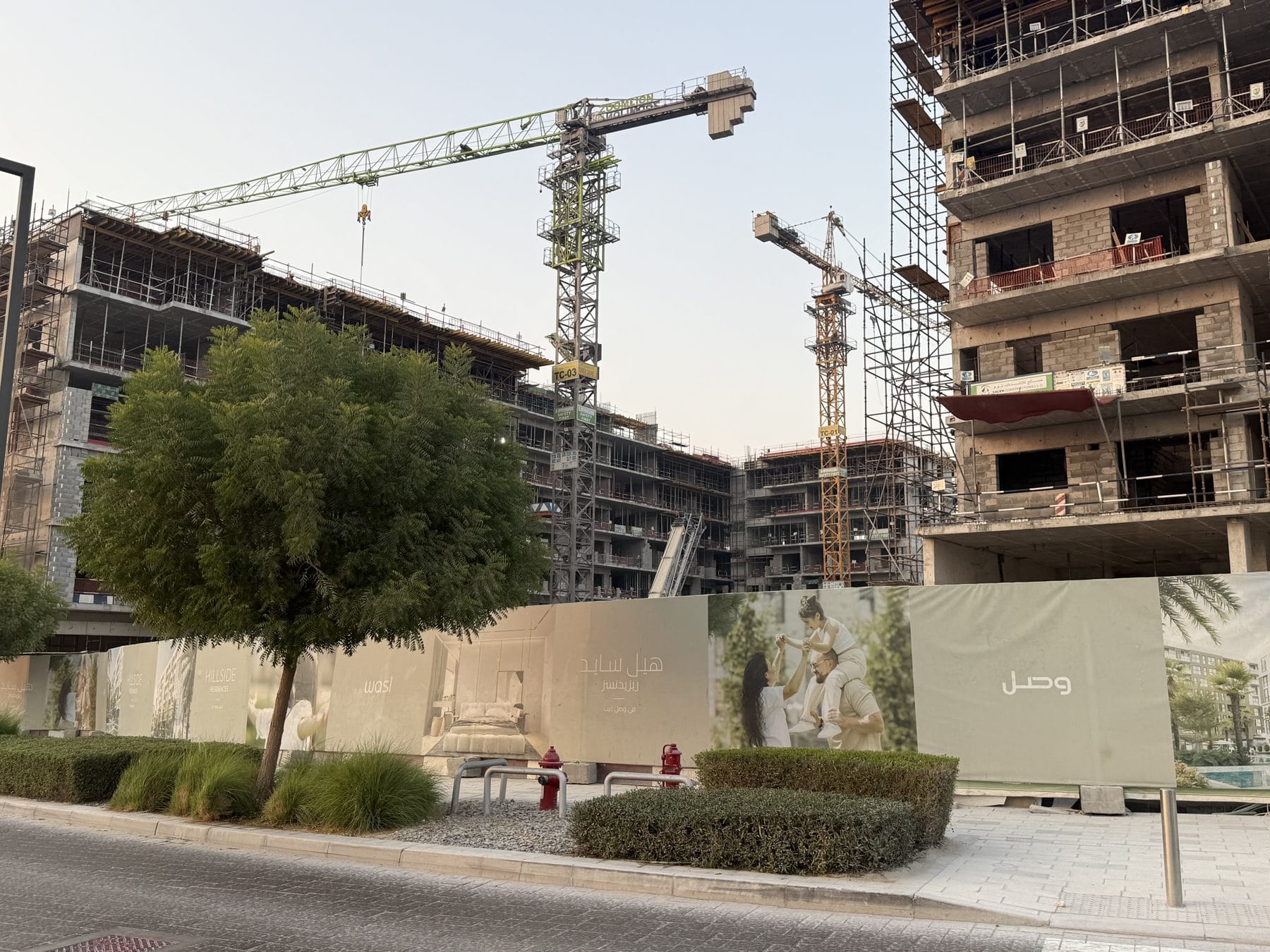 Hillside structures and tower cranes — site visit, September 2026.
